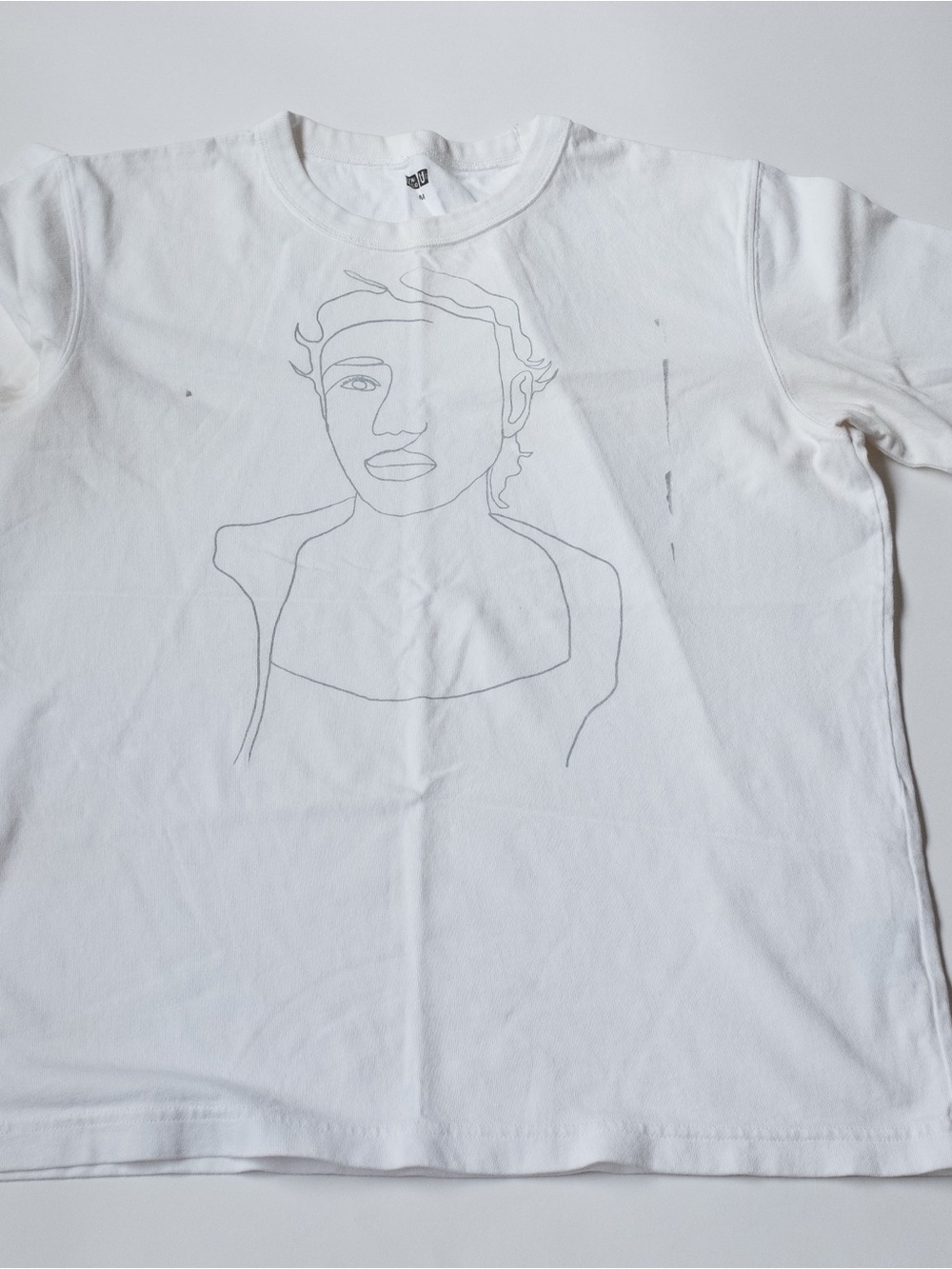 Uniqlo White Crewneck T-Shirt with Subtle Gray Line-Art Portrait